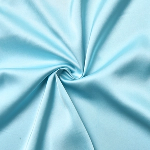 Dettaglio del tessuto in raso di seta azzurro con trama liscia e drappeggio elegante