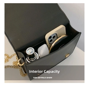 Detail showing internal capacity of black punk crossbody bag with gold chain strap