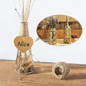 Clear glass vase set with heart-shaped kraft tag, dried plants and natural hemp rope décor