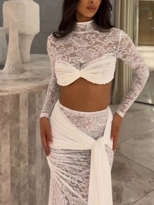 Close-up of white lace two-piece set featuring sheer mesh texture and ruched bodice detail