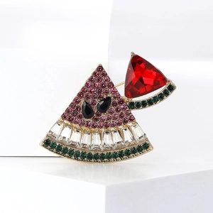 Detail of watermelon brooch featuring pink and green rhinestones on golden metal base