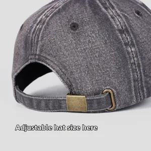 Detail view of adjustable metal buckle on vintage washed grey denim baseball cap