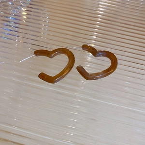 Brown heart-shaped hoop earrings with a glossy amber-like finish and metal posts