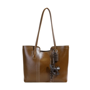 Brown large capacity leather tote bag with contrast stitching and cartoon charms