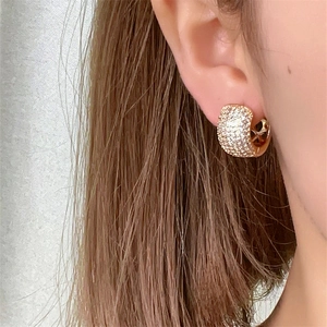 Elegant gold-plated circular hoop earrings with pave-set cubic zirconia on female model