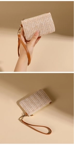 Detail of beige straw coin purse with brown leather wrist strap and golden zipper closure