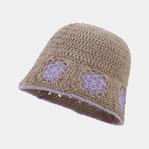 Detailed close-up of crochet hollow flower pattern and purple trim on a beige bucket hat