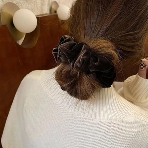 Chouchou géant en velours marron pour femme coiffé en chignon aux tons élégants