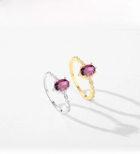 Detailed macro view of S925 silver and gold rings with oval purple stones and wavy bands