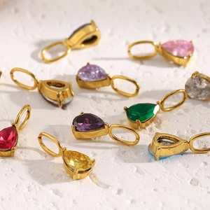 Macro shot of 18K gold teardrop pendants with colorful birthstones in various vibrant shades