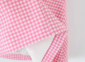 Detailed close-up of pink and white gingham fabric hem with high-quality inner lining stitching