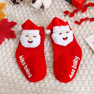 Detail of red Christmas baby socks with plush Santa decor and non-slip kiss baby print