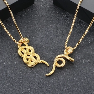 Détail macro du pendentif serpent doré avec yeux rouges et écailles texturées