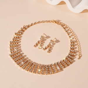 Close-up of sparkling rhinestone necklace and tassel earrings set in gold finish