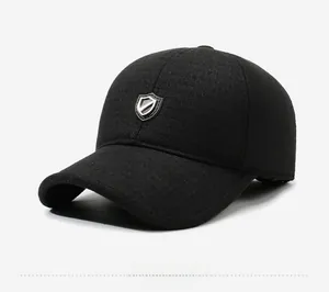 Détail de la casquette de baseball noire en laine avec un emblème bouclier argenté