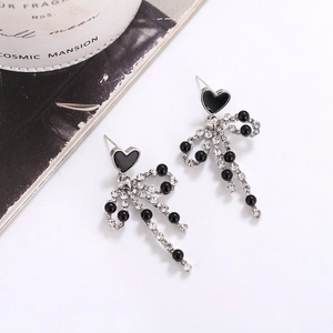 Detail view of copper heart bow earrings with black beads and sparkling crystals