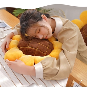 Close-up of a soft sunflower plush cushion with yellow petals and brown center