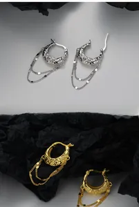 Detail of S925 sterling silver C-hoop earrings with lava texture and tassel chains