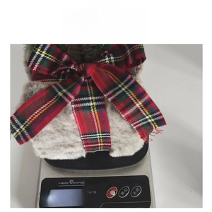 Detail shot of plush grey Christmas decoration weighing 52 grams on a digital scale