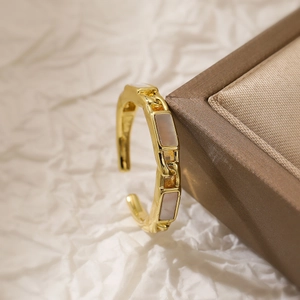 Detailed macro view of gold-plated chain ring with rectangular mother-of-pearl inlays