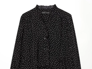 Detail of black polka dot ruffle neck shirt with buttons and long sleeves