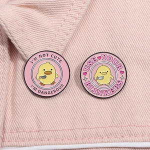 Close-up of pink enamel pins with funny chicken illustrations and English slogans