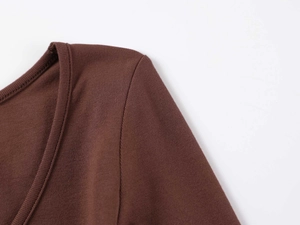 Detail of soft ribbed cotton fabric and U-neck stitching on the dark brown bodysuit