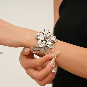 Macro detail of silver floral open cuff bracelet with layered petals and hollow leaf structure