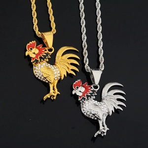 Detail of rooster pendants with crystals and red enamel on gold and silver twist chains
