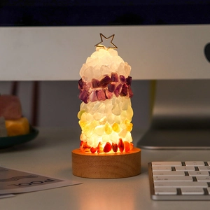 Close-up of a crystal Christmas tree night light with colorful stones and a wooden base