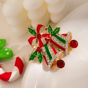Close-up of festive Christmas bell brooch with red bow and sparkling rhinestones