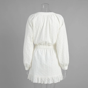 Vue détaillée du dos de la robe blanche brodée montrant le motif losange et les volants