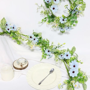 Close-up of light blue silk daisy wreath with green leaves for wedding party decor