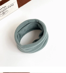 Detailed view of grey-green elastic towel hair ring on a clean white surface