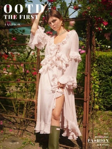 Detail of light pink tiered ruffled dress with elegant long sleeves and flowy chiffon fabric