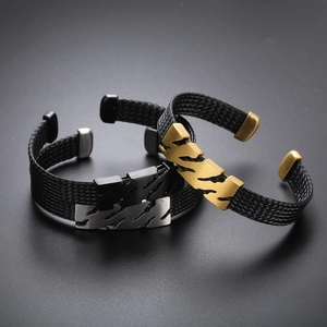 Détail de bracelets en acier inoxydable tressé en argent et or avec textures industrielles