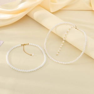 Detail of French vintage pearl necklaces with gold plated titanium steel lobster clasps on cream silk fabric