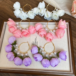 Detail of floral hoop earrings with silk petals and pearls in a jewelry tray