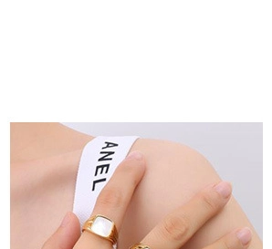 Detalle de un anillo dorado con incrustación cuadrada de nácar blanco y banda pulida