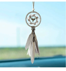 Detail of dream catcher car pendant with metal deer head and grey feathers