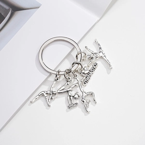 Detailed view of silver gymnastics keychain featuring athlete figures and engraved heart