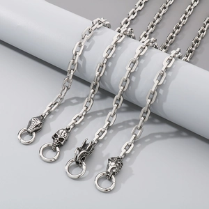 Detailed shot of steel chain links featuring snake, skull, dragon and lion pendants