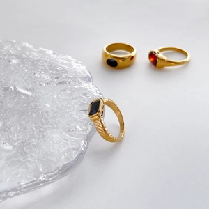 Detailed close-up of retro gold-plated rings with black onyx and ruby style stones