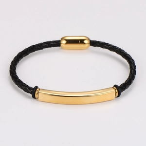 Detailed view of black braided leather bracelet featuring a polished gold magnetic clasp