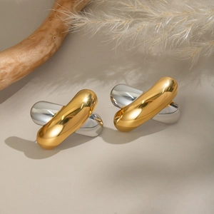 Macro detail of criss-cross two-tone metal stud earrings with 18K gold and silver finish