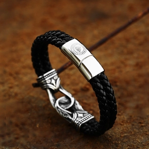 Close-up of black braided leather bracelet with Viking rune engraved silver metal clasp
