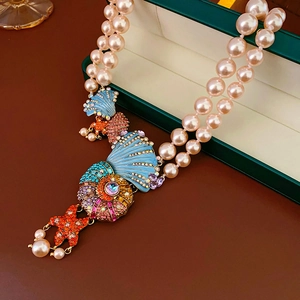 Macro detail of vintage shell and starfish pendant with colorful enamel and sparkling crystals