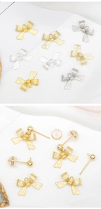 Dettaglio macro di ciondoli a fiocco satinati oro e argento con perni per gioielli DIY