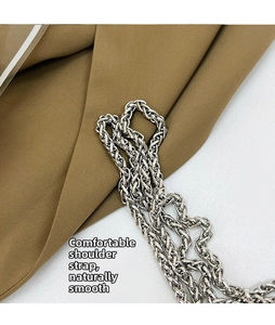 Detail of silver metal chain strap with polished oval links on a crossbody bucket bag