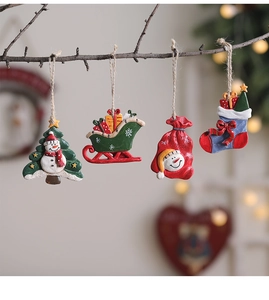 Detail view of resin Christmas ornaments featuring Santa and snowman on branches